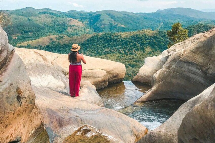 A person standing on a rock overlooking a river with mountains in the background. 4
