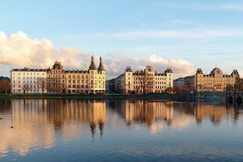 Un conjunto de edificios históricos junto a un lago tranquilo con reflejos nítidos. 3
