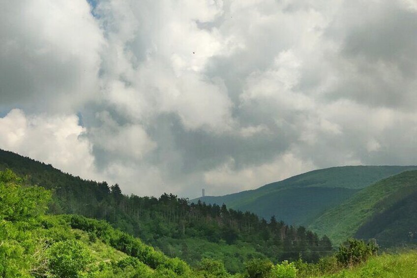 A lush green valley with rolling hills and a cloudy sky. 4