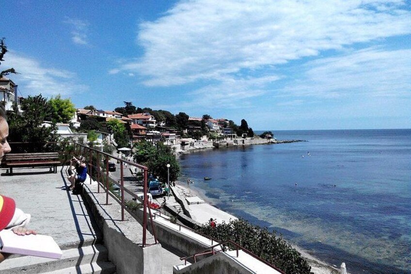 A coastal town with a clear sky, a promenade, and buildings along the waterfront. 3