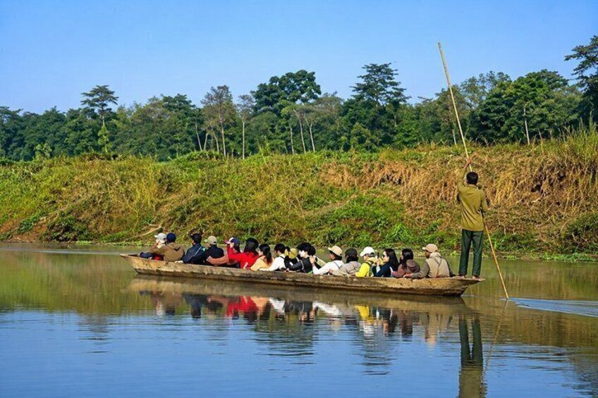 A boat with passengers and a guide on a calm river surrounded by greenery. 3