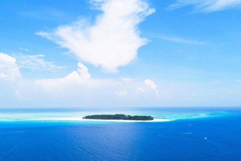 A clear blue ocean with a small island in the distance. 1