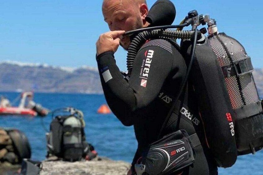 A person wearing a wetsuit and carrying a backpack with a camera and other equipment. 4