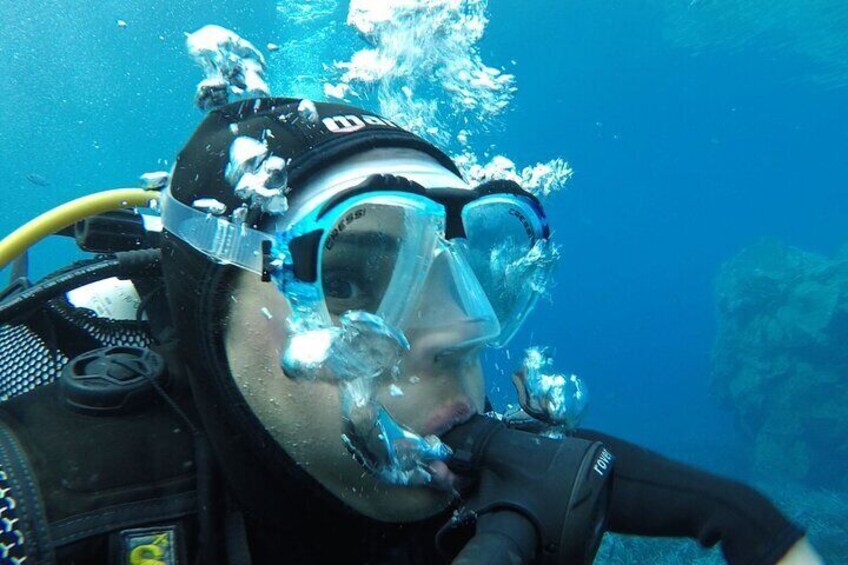 Un plongeur, équipé d’un masque de plongée et d’un tuba, entouré de bulles et immergé sous l’eau. 1
