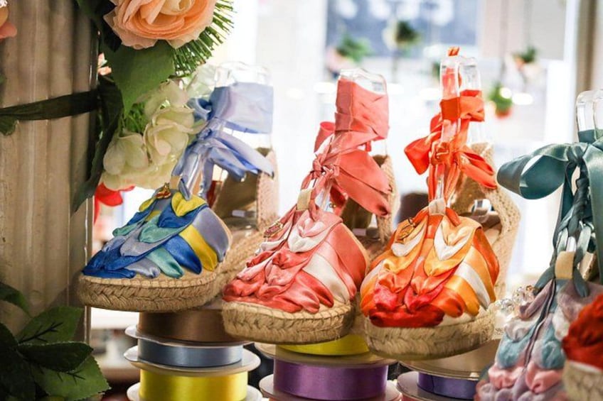 A display of colorful shoes with ribbons tied around them. 2