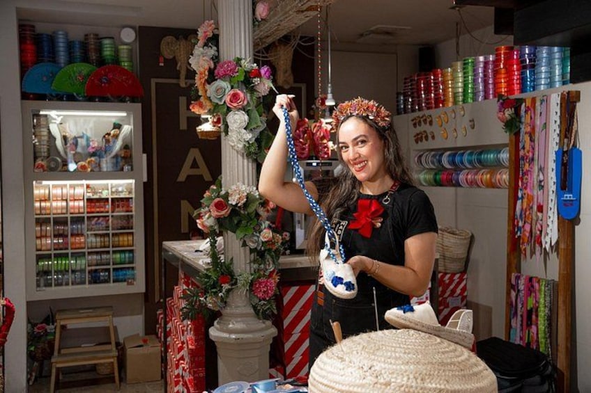 A person in a craft store holding a blue and white beaded necklace. 5