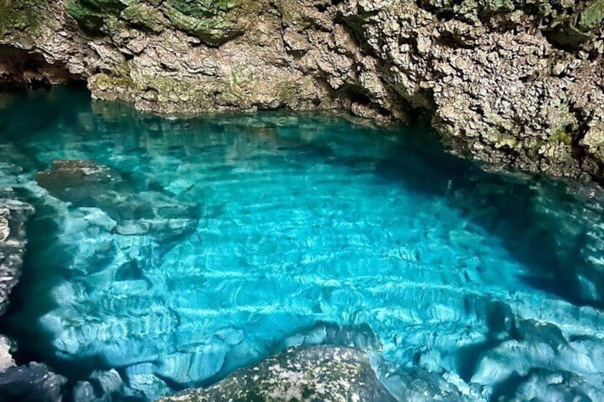 A clear blue pool surrounded by rocky terrain. 2