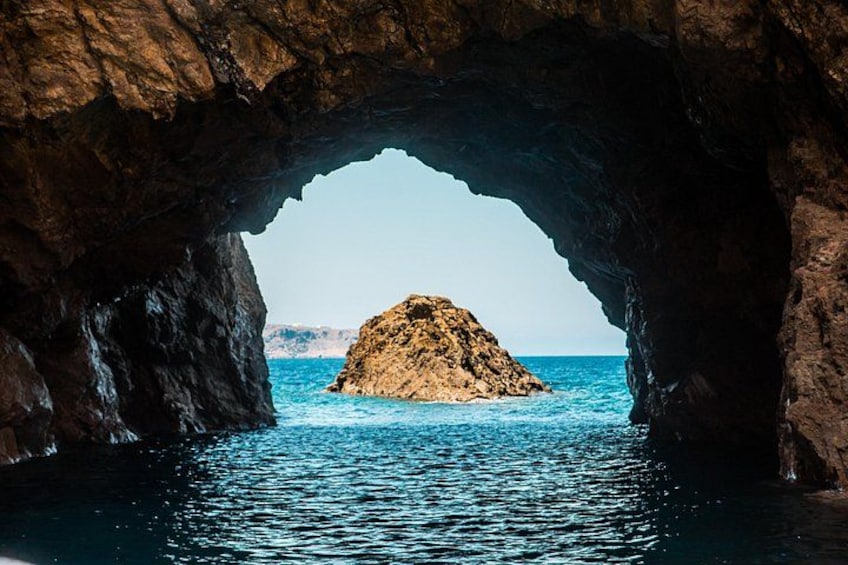 Une arche rocheuse naturelle avec une petite île dans l’eau. 5