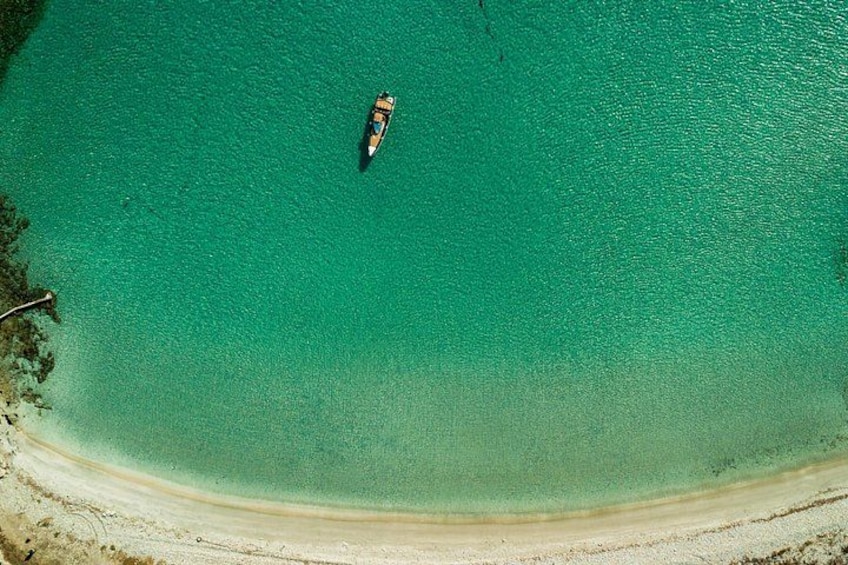 A boat on turquoise water near a sandy beach. 4