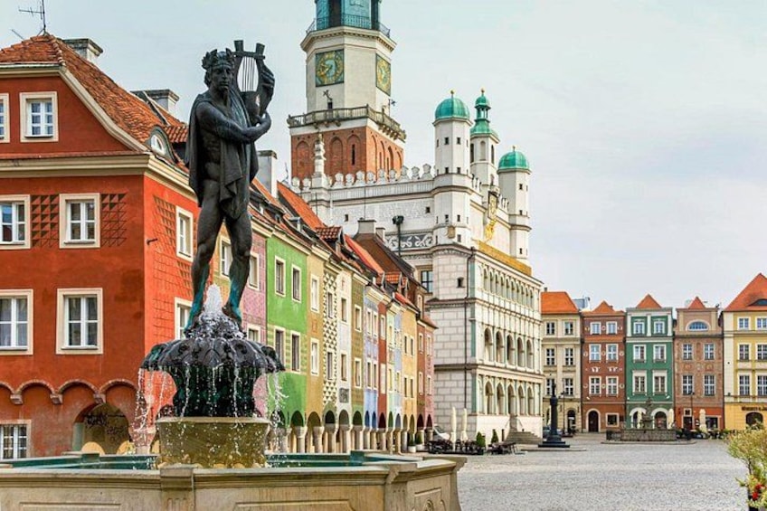 Una piazza storica con edifici colorati, una statua e una fontana. 3