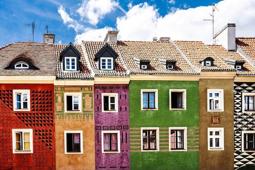 Una serie di edifici colorati con stili architettonici diversi e tetti in tegole. 5