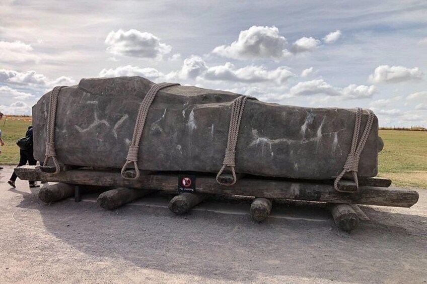A large stone structure on a trailer in an open field. 4