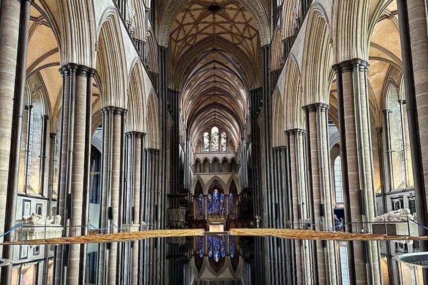 A cathedral interior with high vaulted ceilings, large columns, and stained glass windows. 5
