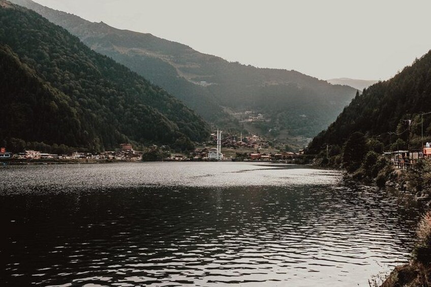 A river with a bridge, surrounded by forested hills. 2