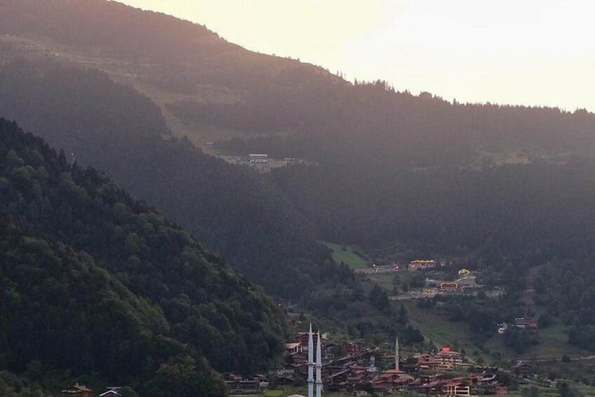 A valley with a small settlement, a church spire, and a hill with dense forest. 3