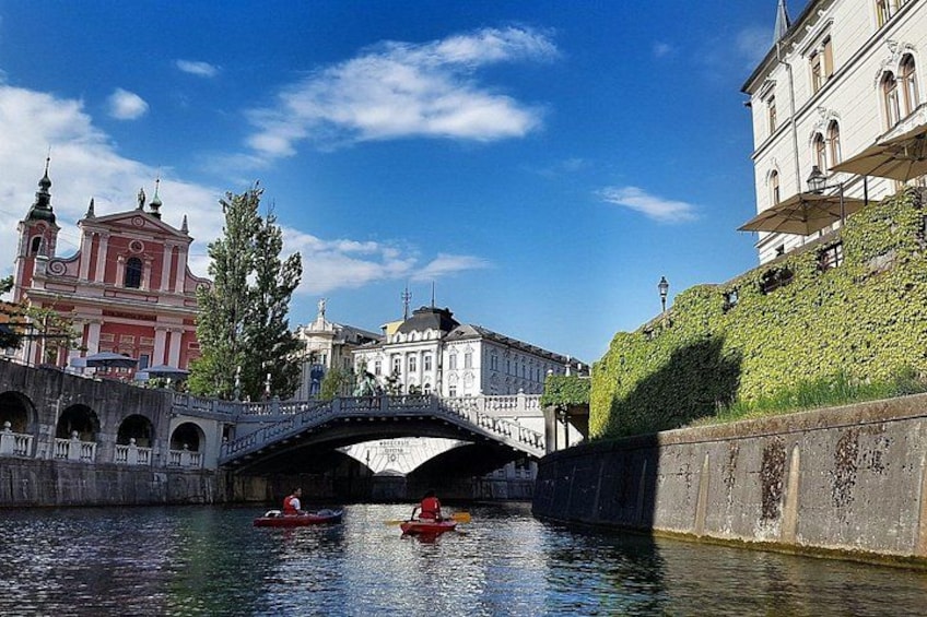 A bridge over a river, a red boat, and historic buildings. 1