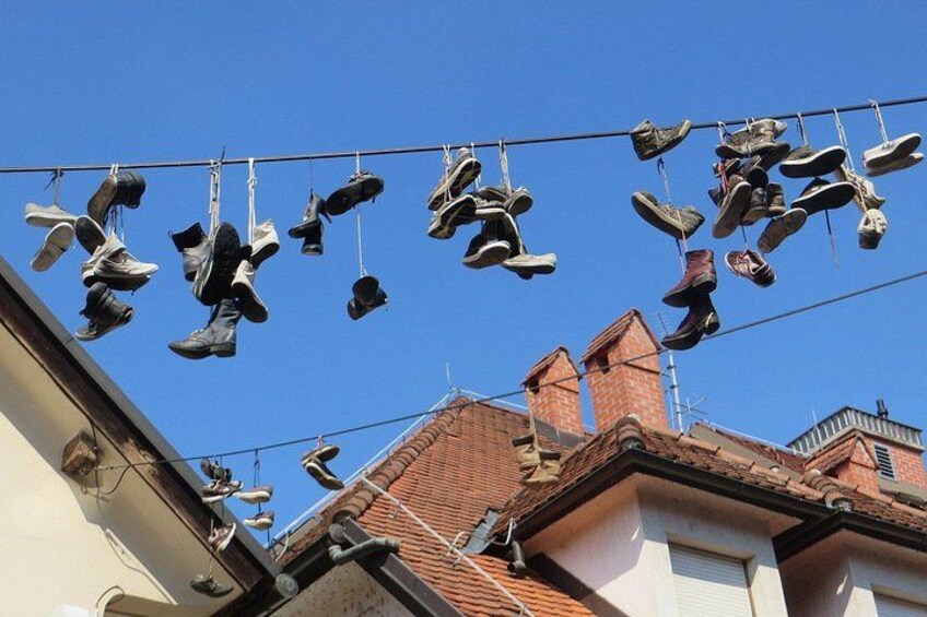 A clothesline with multiple pairs of shoes hanging. 2