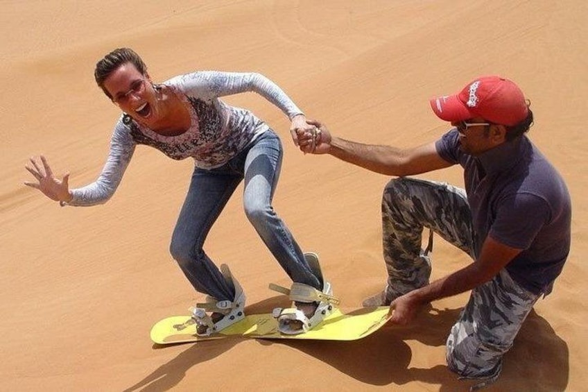 A person on a yellow board in a desert. 1