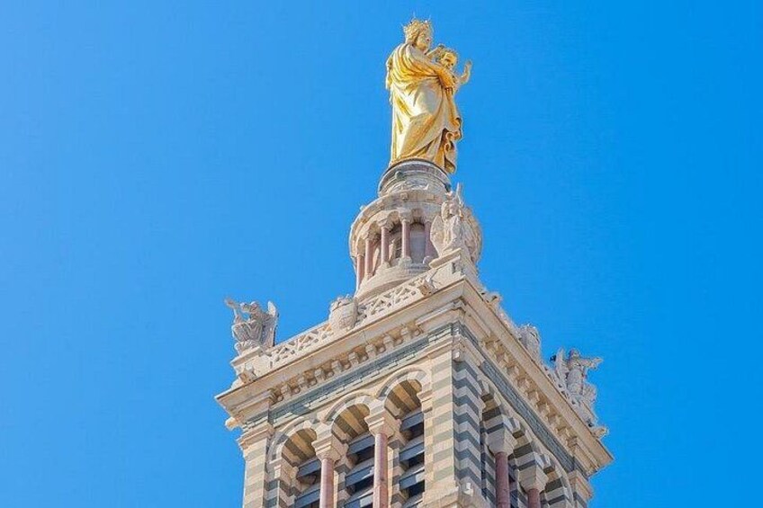 Een hoog gebouw met een gouden beeld op de top. 3