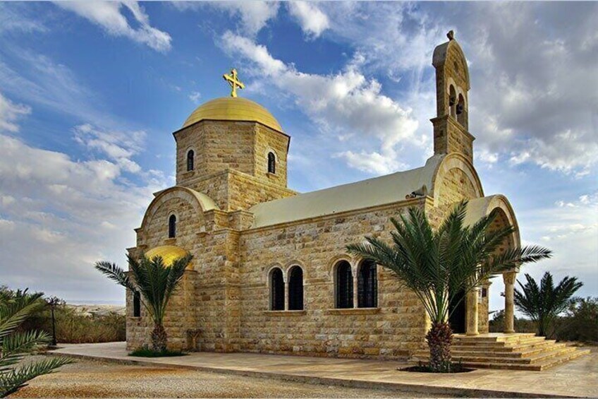 A stone church with a golden dome and a bell tower. 3