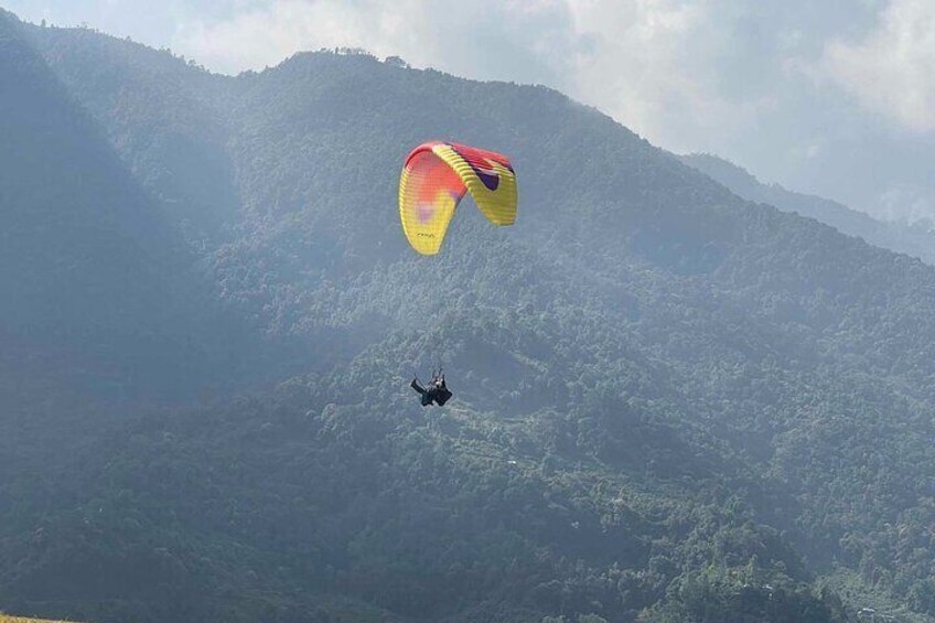 Una persona practicando parapente sobre un paisaje montañoso. 2