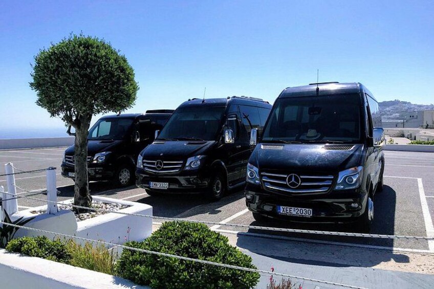 En parkeringsplads med flere sorte Mercedes-Benz biler, et lille træ og en klar blå himmel. 5