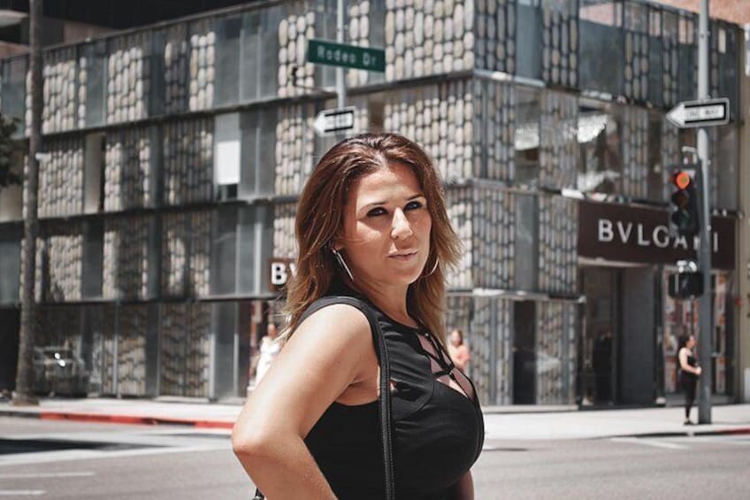 A woman standing on a street with a building in the background. 3