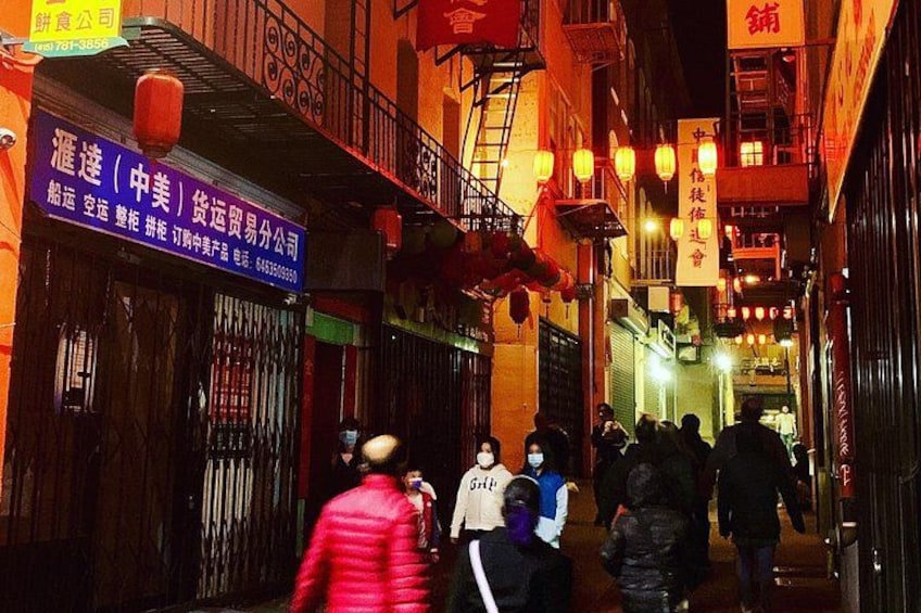 A narrow alleyway with traditional buildings, lanterns, and signs in a foreign language. 5