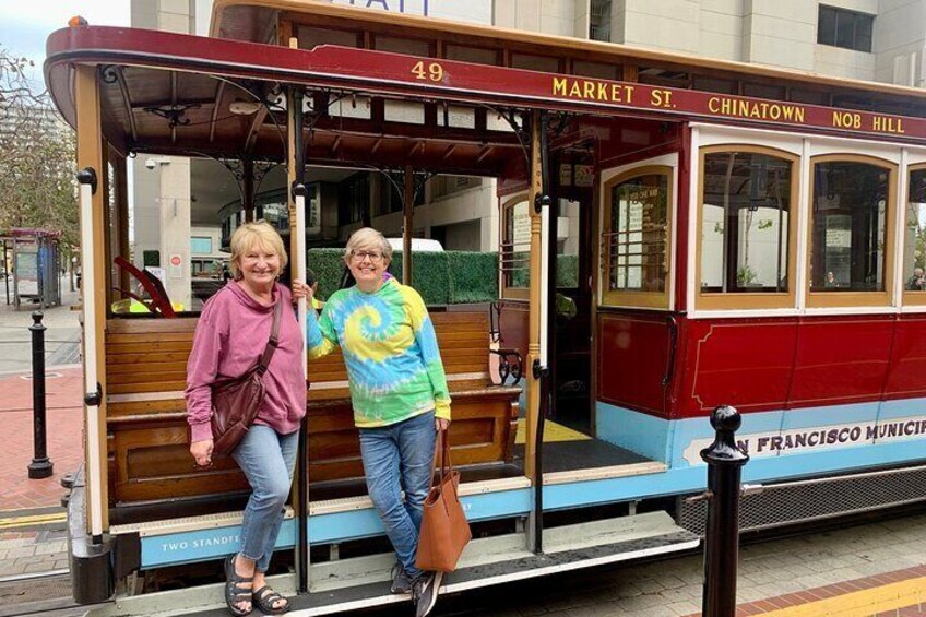 Een oude trolley met twee passagiers die vooraan staan. 1
