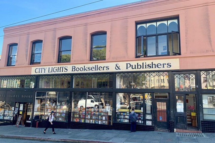 Een winkelvoorgevel met een bord waarop staat 'CITY LIGHTS Booksellers & Publishers'. 3