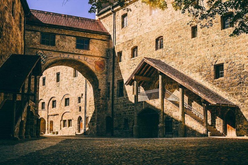 A stone archway, a cobblestone street, and a building with a tiled roof. 5