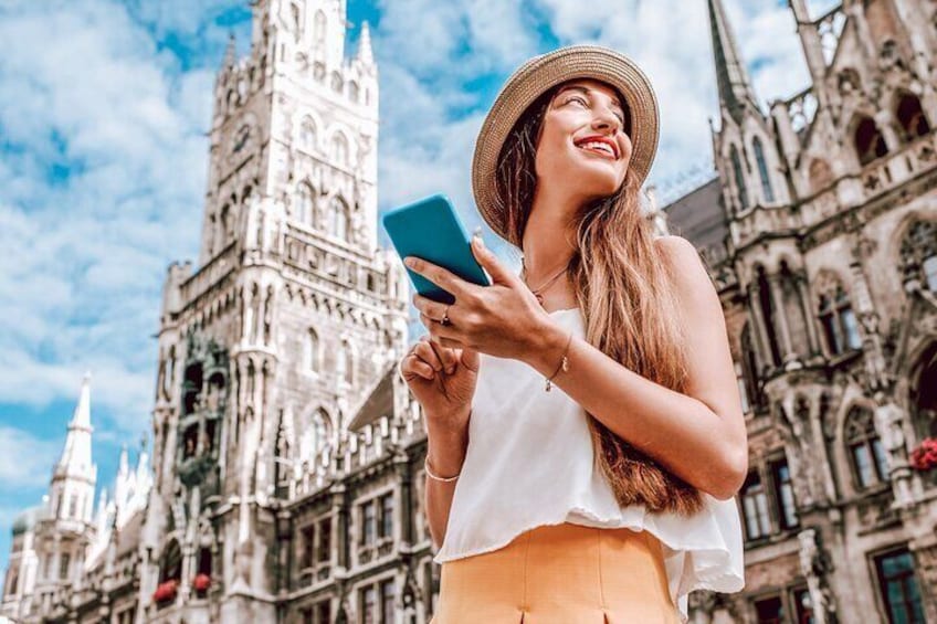 A person in a white top and yellow skirt standing in front of a historic building with intricate architecture. 1