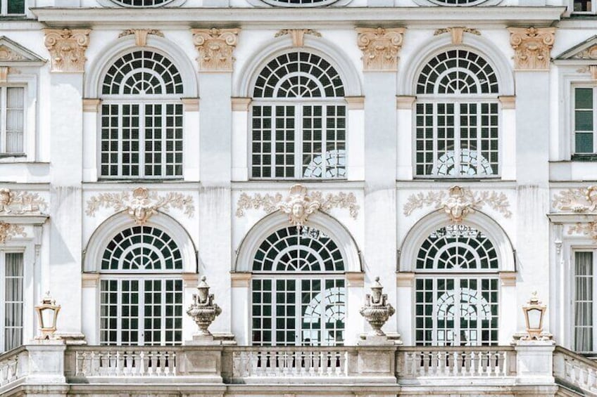A building facade with arched windows and decorative sculptures. 3