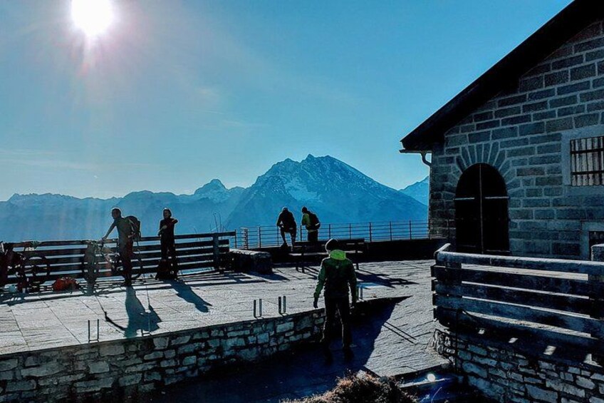 A group of people on a stone platform with a mountain in the background. 5