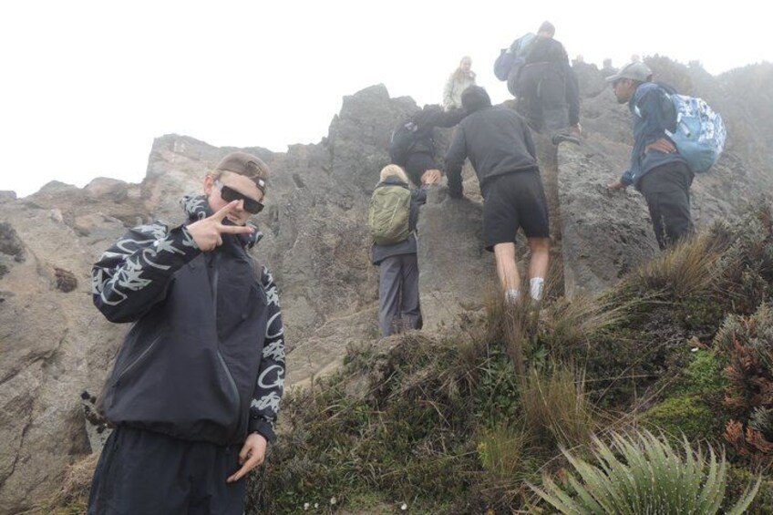 Een groep mensen wandelt een rotsachtig bergpad op. 5