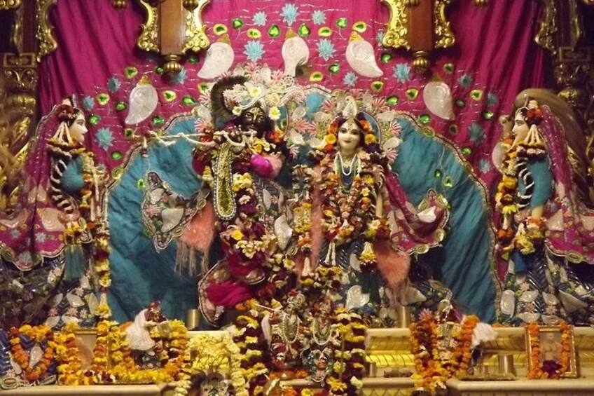 A religious shrine with multiple deities adorned with flowers and ornaments. 5