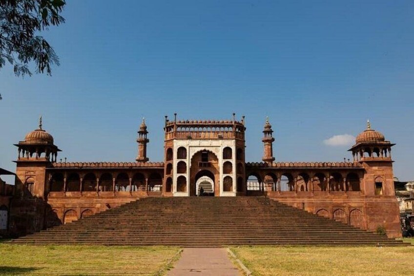A large, historic building with a grand entrance, multiple arches, and two domed towers. 5