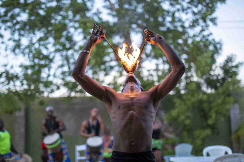 A shirtless man balancing a torch on his head. 4