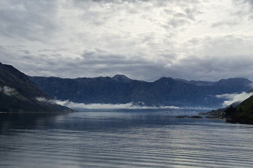Un lago tranquilo rodeado de montañas bajo un cielo nublado. 4