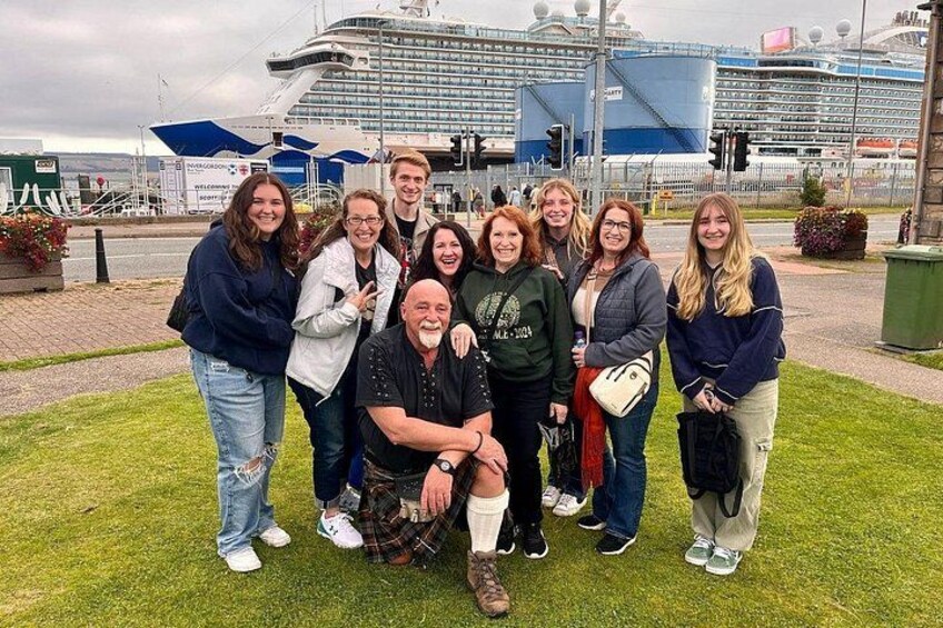 Un groupe de personnes posant devant un navire de croisière. 2