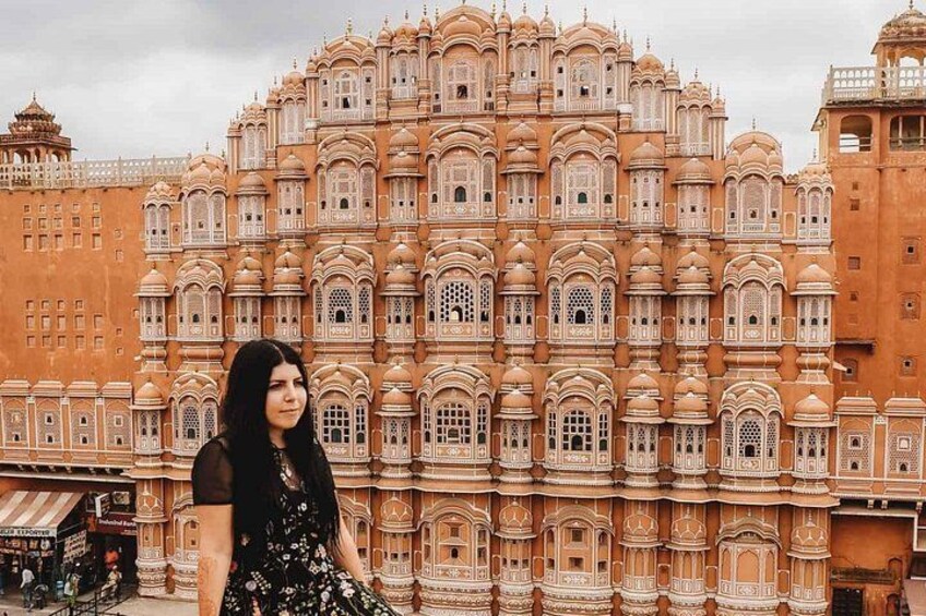 A woman in front of a large, ornate building with multiple domes and intricate designs. 2