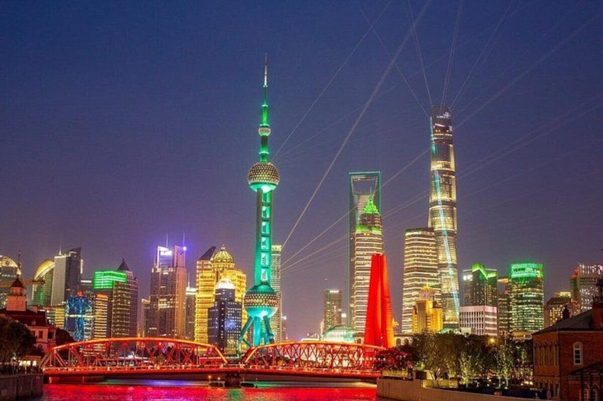 A city skyline at night with illuminated buildings and a prominent tower. 4