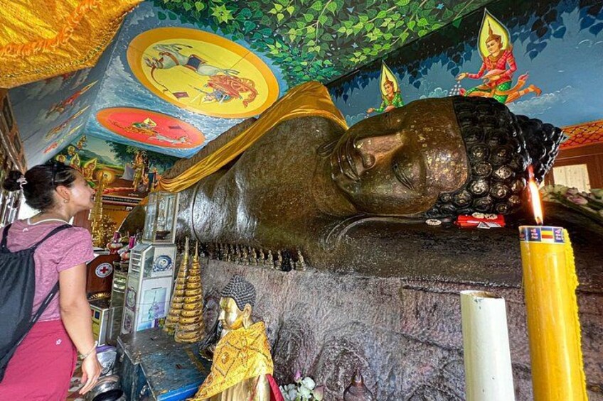 A large Buddha statue with a yellow candle in front. 2