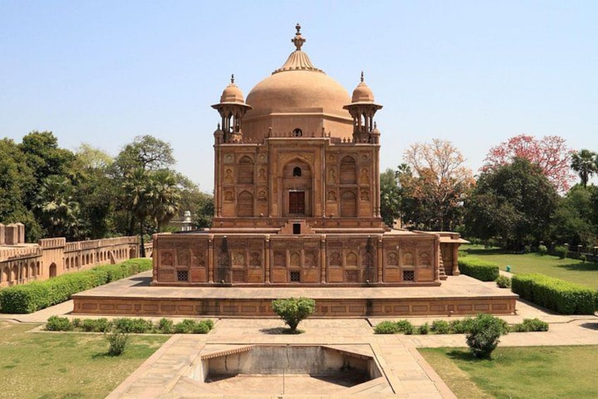 A large, ornate building with a central dome and smaller domes on either side, surrounded by a well-manicured garden. 3