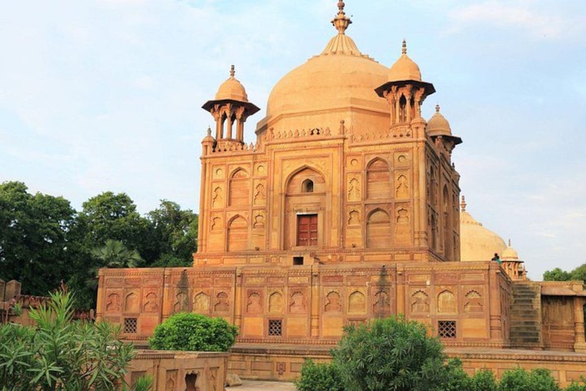 A large, ornate building with domes and intricate carvings, surrounded by greenery. 1