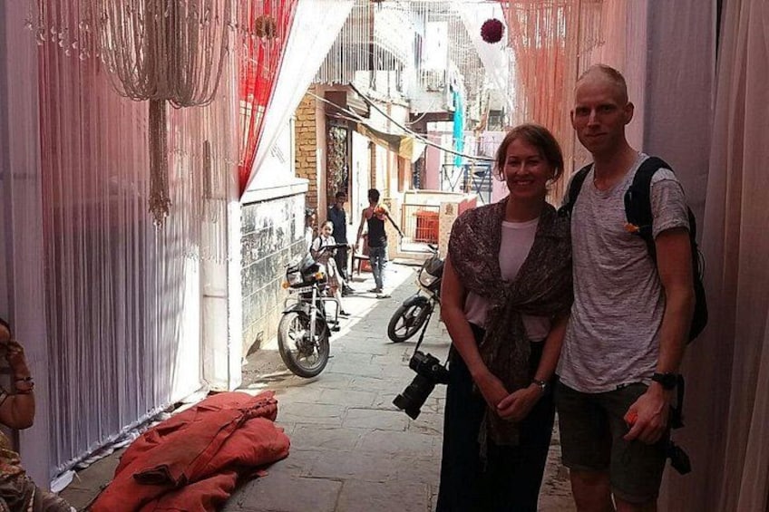 A narrow alleyway with draped fabric on either side, a motorcycle parked in the background, and a person holding a camera. 5