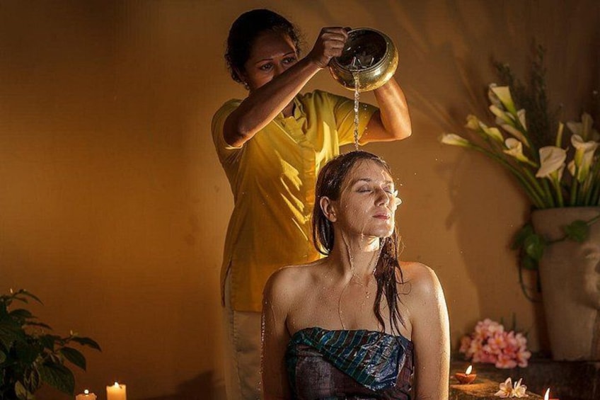 Eine Person erhält eine Kopfmassage, neben sich eine Wasserschale. 1