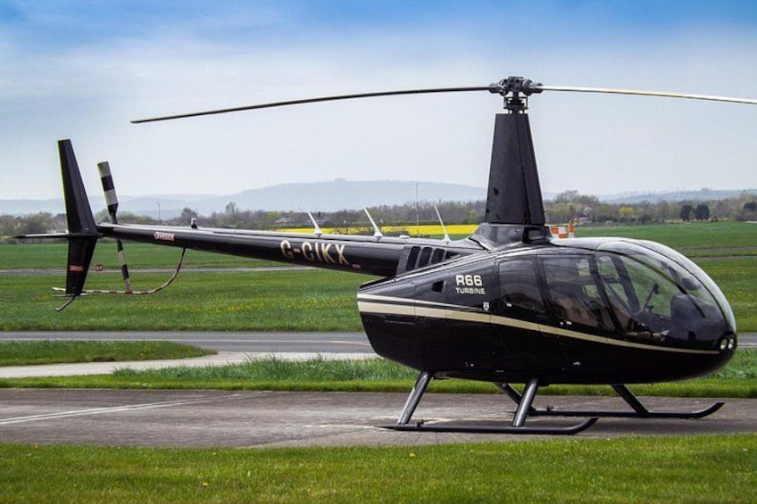 Un hélicoptère noir immatriculé G-CIKX se trouve sur une piste d’atterrissage. 2