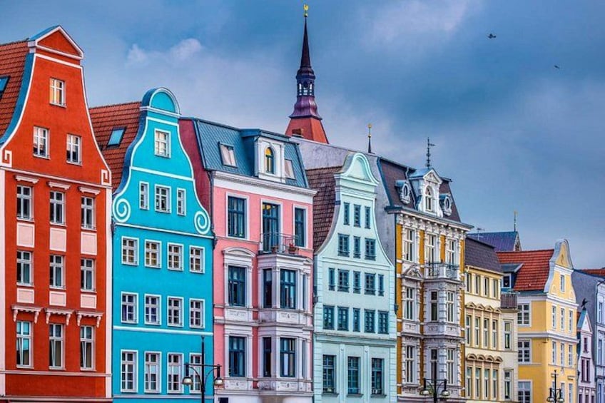 Colorful historic buildings with a church steeple. 1