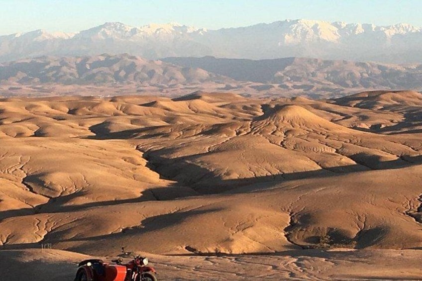 Un paysage désertique avec des dunes de sable et des montagnes à l’horizon. 5